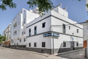a white building on the side of a street at Apartamentos Bellamar in Barbate