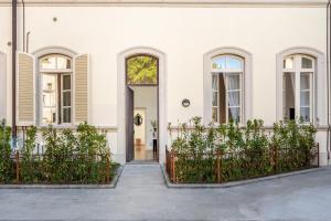 a white house with a door and a fence at Maison Mirò with private parking in Lucca