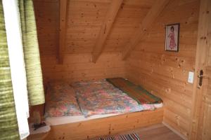 a bed in a log cabin with a wall at Ferienhaus Klippitzblick in Klippitztorl