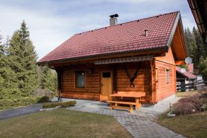 a wooden cabin with a picnic table in front of it at Ferienhaus Klippitzblick in Klippitztorl