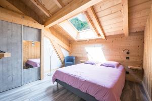 a bedroom in a wooden cabin with a bed and a window at Chalet - Le crey rond in Valloire