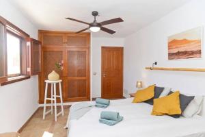 a bedroom with a white bed and a ceiling fan at Casa Jenabe in La Vegueta
