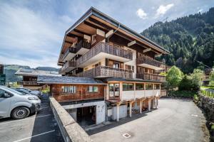 a large building with a car parked in a parking lot at La Flèche d'Or in Châtel