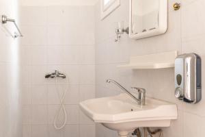 a white bathroom with a sink and a shower at Sifnos studio 5 in Sifnos
