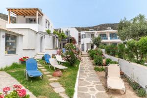 a patio with chairs and flowers and buildings at Sifnos studio 5 in Sifnos
