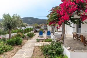 a patio with a table and chairs and flowers at Sifnos studio 5 in Sifnos +8 photos