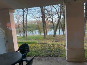 a porch with a table and chairs and a view of a lake at Lake view Appartment in Monflanquin