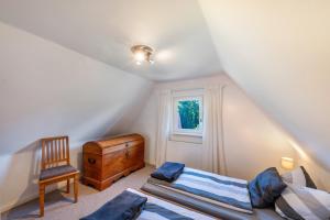a attic bedroom with two beds and a chair at Sonnenhaus am See in Schwerin