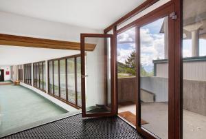 an open glass door in a room with a balcony at Appartamenti Larice Pila in Pila
