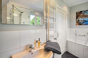 a bathroom with a sink and a tub and a mirror at Sonnenhaus am See in Schwerin +16 photos