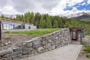 a stone wall in front of a house at Appartamenti Larice Pila in Pila