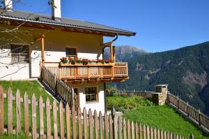 a house with a balcony with flowers on it at Thalhof Kornigl in Ultimo