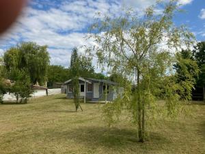 a small house in a yard with a tree at Les Chalets de Babeth et Cathy in Trouan-le-Grand