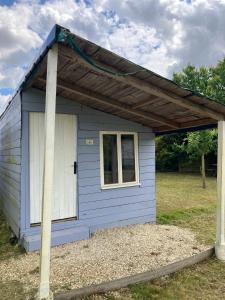 a blue shed with a gambrel roof at Les Chalets de Babeth et Cathy in Trouan-le-Grand