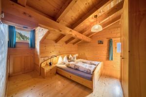 a bedroom with a bed in a wooden room at Thalhof Kornigl in Ultimo