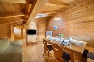 a dining room with a large wooden table and chairs at Thalhof Kornigl in Ultimo