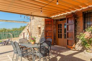 a table and chairs on the patio of a house at Masia Can Vilar in Maçanet de la Selva