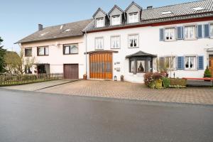 a large white house with a large wooden door at Ferienwohnung Katharina in Laufeld
