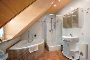 a bathroom with a shower and a tub and a sink at Ferienwohnung Katharina in Laufeld