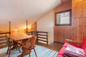 a dining room with a table and a red couch at La Baita Verde in Motta +33 photos