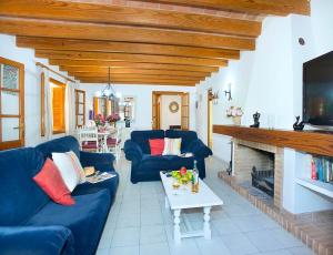 a living room with two blue couches and a fireplace at Villa Tancotes in Pollença
