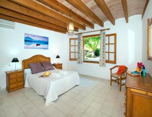 a bedroom with a bed and a table and a window at Villa Tancotes in Pollença +17 photos