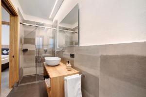 a bathroom with a sink and a shower at Haus Nummer 9 in Marlengo