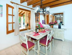 a dining room with a table and chairs and a kitchen at Villa Tancotes in Pollença