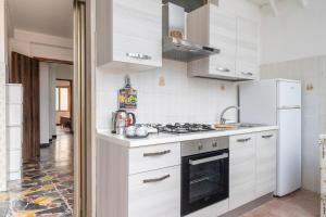 a white kitchen with a stove and a refrigerator at Jerzu Centro 2 in Jerzu +8 photos