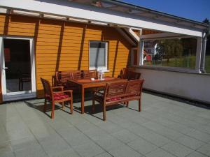 a wooden table and chairs on a patio at Fewo 1 - Osterberg in Liebenau