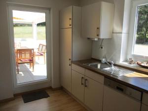 a kitchen with a sink and a door to a patio at Fewo 1 - Osterberg in Liebenau +3 photos