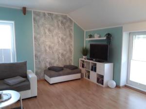 a living room with a couch and a television at Fewo 1 - Osterberg in Liebenau