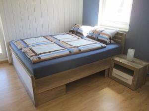 a bed with a wooden frame in a room at Fewo 1 - Osterberg in Liebenau