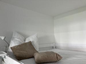 a white room with a bed with a pillow at Somski Saalbach in Saalbach-Hinterglemm