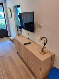 a flat screen tv sitting on top of a wooden cabinet at Somski Saalbach in Saalbach-Hinterglemm
