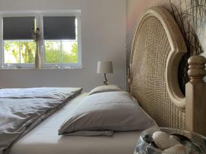 ein Schlafzimmer mit einem Bett mit Kopfteil und einem Fenster in der Unterkunft Taunusglück in Glashütten
