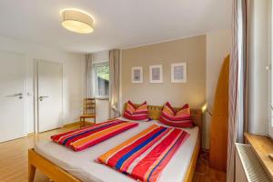 a bedroom with a large bed with colorful pillows at Ferienwohnung Peitz in Eslohe