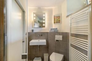 a bathroom with a sink and a toilet and a mirror at Ferienwohnung Peitz in Eslohe +21 photos