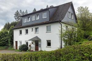 a white house with a black roof at Ferienwohnung Peitz in Eslohe