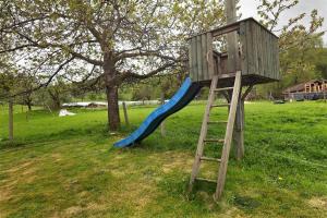 a wooden play tower with a blue slide at Ferienwohnung Peitz in Eslohe