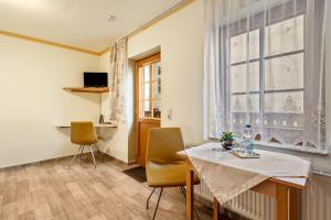 a dining room with a table and chairs and a window at Pension Ufert in Meißen