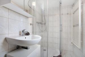 a white bathroom with a sink and a shower at Bäckerhus - Ferienwohnung 1 in Wiek auf Rügen