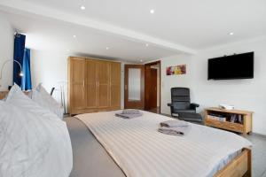 a bedroom with a large bed with a television on the wall at Bäckerhus - Ferienwohnung 1 in Wiek auf Rügen