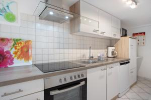a kitchen with white cabinets and a sink at Bäckerhus - Ferienwohnung 1 in Wiek auf Rügen +11 photos