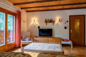 a living room with a flat screen tv and a couch at Chalet Les Airelles in Mittlach