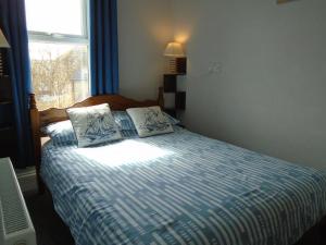 a bedroom with a bed with two pillows and a window at The Florian in Weymouth