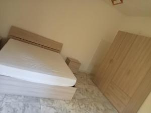 a small bedroom with a bed and a wooden door at Casa Azzurra 56 in Bova Marina