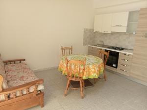 a kitchen with a table and chairs in a room at Casa Azzurra 56 in Bova Marina