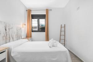 a room with two beds with a teddy bear on the bed at Apartamentos Bellamar in Barbate