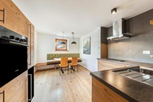 a kitchen with a table and chairs in it at Naturoase Stegerhof Apt Iris in Trodena
